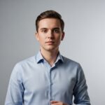 Profesjonalny młody dorosły w jednolitej koszuli na jasnym tle, patrzący prosto w obiektyw
